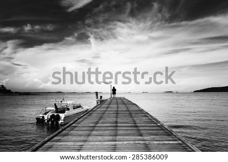 Woman alone on bridge to the ocean black and white style