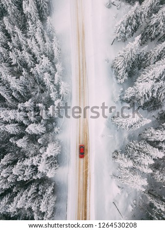 Car driving on winter road. seen from above. Aerial photography. Location: Rarau Mountains, Romania.