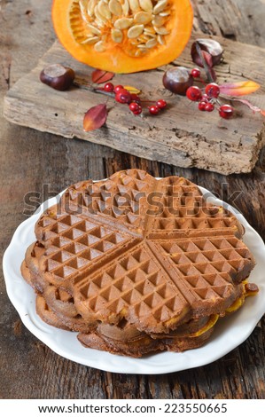 Pumpkin Belgium waffles on a plate in the background of an old board