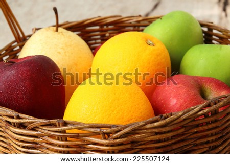 Variety of fruits into basket on old wood floor