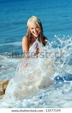 Pretty girl playing in surf at beach