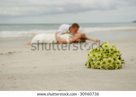 stock photo Wedding flowers on beach with bride groom in background