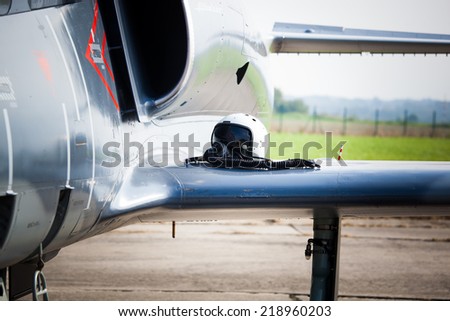 Detail of military fighter/interceptor/jetplane jet engine and wing with pilot\'s oxygen mask and helmet lying on, ready to take off in case of terrorist attack (colorful image)