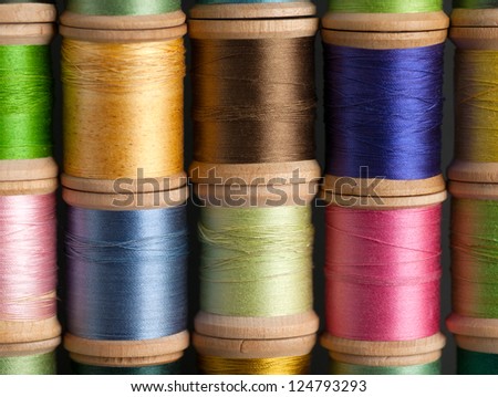 Stacks of Vintage Threads on Wooden Spools as a closeup background.
