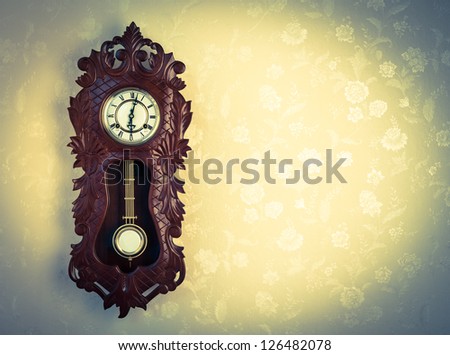 Ornate Wood Wallclock on Wall with Floral Wallpaper, Cross Processed Tones, and Copy Space.
