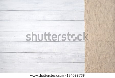 White painted wood board background in horizontal orientation with tan burlap panel on side.   Room or space for copy, text