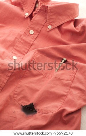 Close Up of a Men\'s Shirt with a Broken Pen that has Leaked Ink, Leaving a Stained Pocket that Needs to be Cleaned on White Background