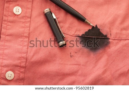 A Close Up of a Broken Pen Resting on the Men\'s Red Shirt Stained with Ink