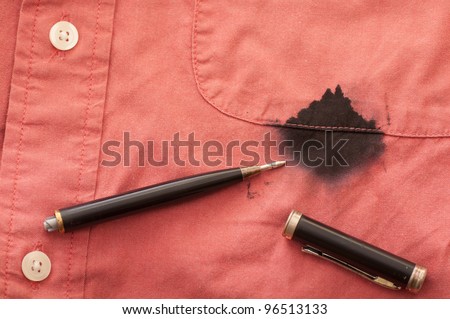 A Close Up of a Broken Pen Resting on the Men\'s Red Shirt Stained with Ink