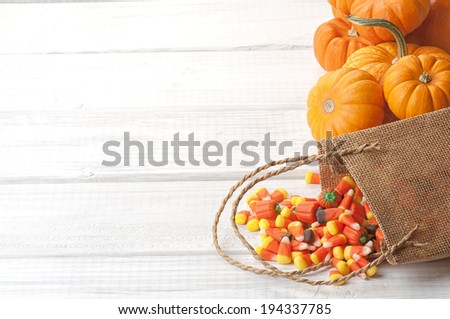 Candy Corn Spilling from Burlap Bag on Rustic White or Gray Wood Board Background with room or space for copy, text.   Horizontal