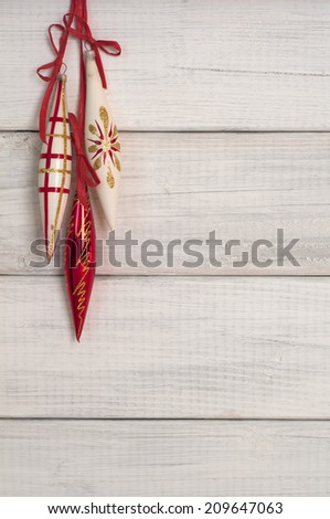 Three Long Vintage Christmas Ornaments Hanging on Rustic White or gray Board Background with Empty Room or Space for copy, text, words.  Vertical still life for card or invitation