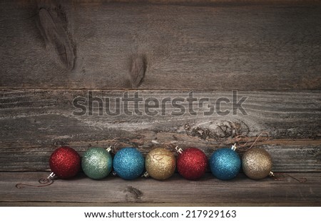 Simple Line of Glitter Christmas Ornaments on Rustic Barn Wood Board Floor and Wall with room or space for copy, text, your words.  Dark Vignette horizontal