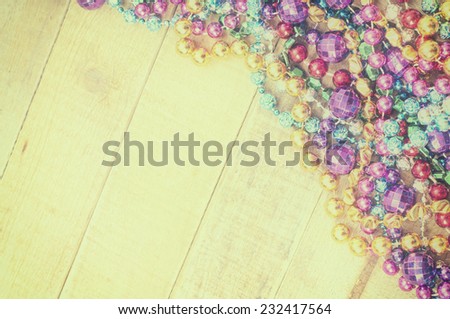 Colorful Beads in corner on Rustic, Painted wood board Background with empty room or space for copy, text, your words.  Works as horizontal or vertical.  Yellow Vintage tone