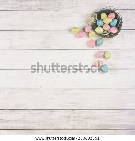 Up Above View Easter Egg Nest Overflowing on Soft Off White or Tan Gray Wood Board Background for room or space for copy, text, your words.  Square can be cropped horizontal or vertical, trendy fade