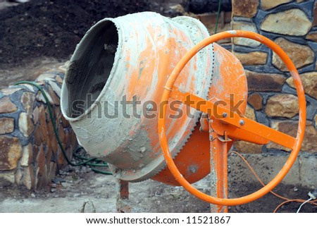 The orange concrete mixer soiled by concrete