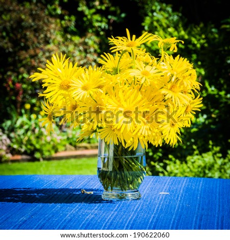 yellow flowers in the vase on the terrace