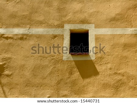 beautiful image of typical mediterranean scenery, little window and shadow on the facade on a sunny day