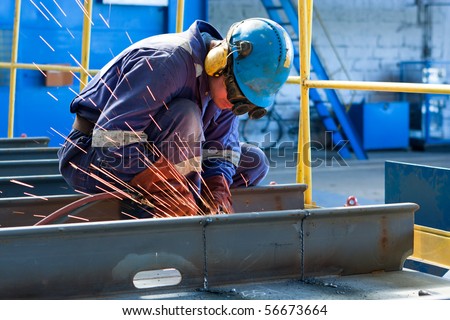 worker weld metal in factory and sparks