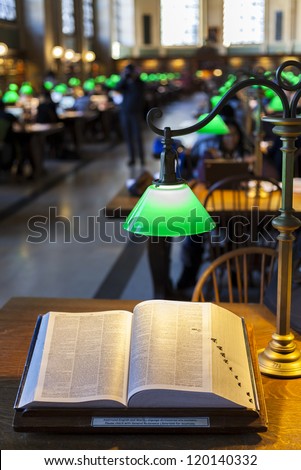 Close-up shot of a book in a busy library with boken background.