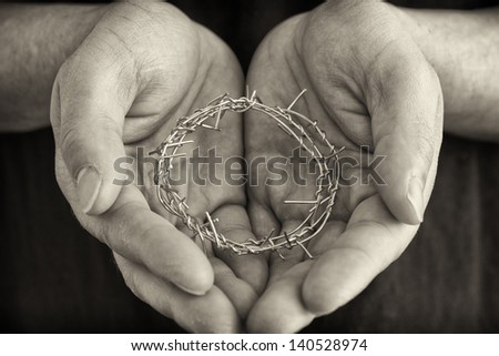 Guy holding a representation of the crown of thorns.
