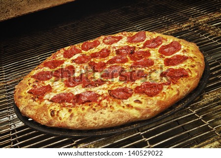 Delicious and fresh pepperoni pizza coming out of the oven.