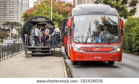 CURITIBA - MARCH 30: Curitiba's public transportation system, photographed on March 30, 2014 with a bus unloading and loading passengers on an integrated bus stop, is a landmark of Parana in Brazil.