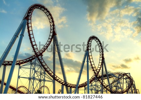 Panoramic shot of a roller coaster\'s loop at sunset.