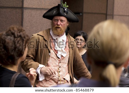 BOSTON, USA - SEPTEMBER 25: An unidentified man dressed in colony-time clothes guides tourists along the Freedom Trail in Boston, MA on Sept. 25, 2011. He tells the history of the city and information on sight seeing.