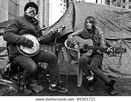 BOSTON, MASSACHUSETTS - NOVEMBER 19: Two members of the Occupy Boston protest sing to the people in its camp in Boston, Massachusetts, USA on November 19, 2011.