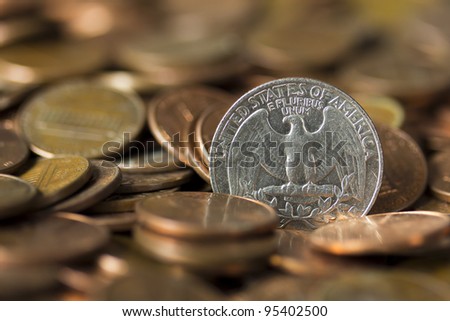 American Quarter of Dollar emerging from a pile of pennies.