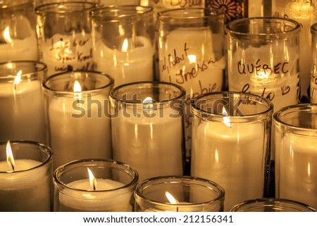 Buch of big candles burning at a catholic church symbolizing religion and God Fearing.