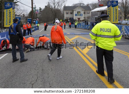 HOPKINTON, USA - APRIL 20: The start line of the Boston Marathon 2015 a few minutes before the start of the competition with staff members, locals, and police going about on April 20, 2015.