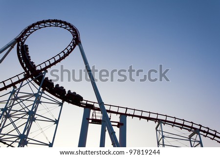 Loop of a roller coaster back lit by the sunset.