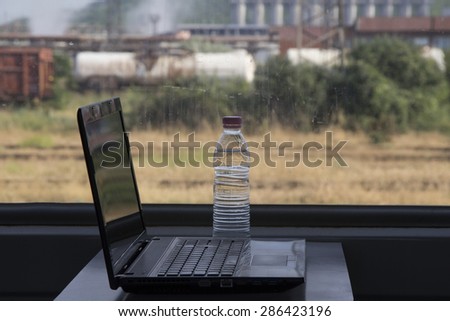 Black laptop on a desk in a train with a view.Concept:Working when travelling,travelling business