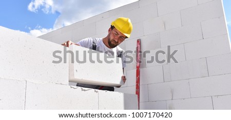 craftsmen at home construction - bricklayers working in work clothes