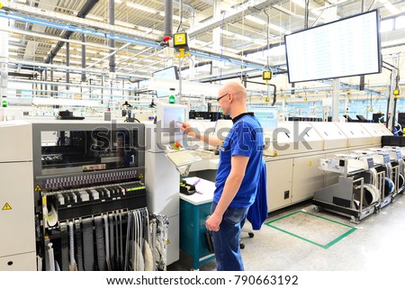 production and assembly of microelectronics in a hi-tech factory - man operates machine in production