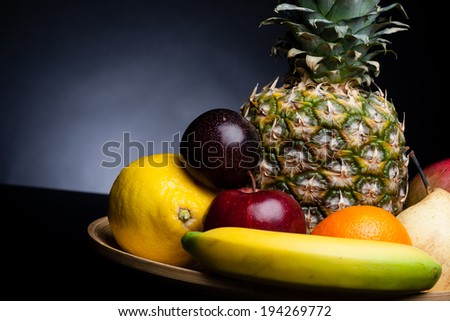 bunch of exotic fruits set up whit pineapple in the middle