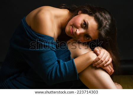 elegant female in dark room relaxing on the floor