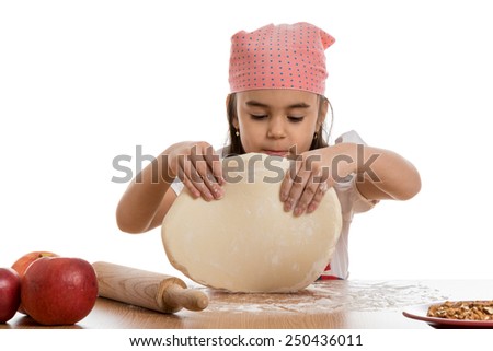 young little girl preparing dough at table with apples and rolling pin