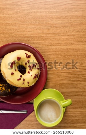 overhead shot of two doughnuts on a marsala plate and coffee