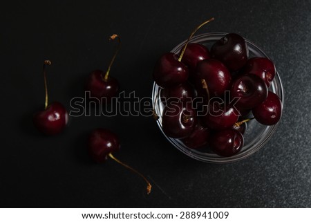 fresh natural cherries in a bowl on black table