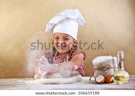 Making the dough for pizza is fun - little chef playing with flour