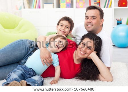 Happy young family with two small kids together at home