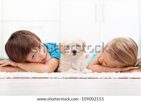 Kids at home with their new pet - a fluffy white dog
