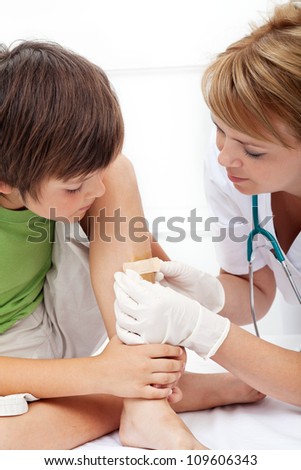 Boy receiving emergency care - getting a patch over injured leg