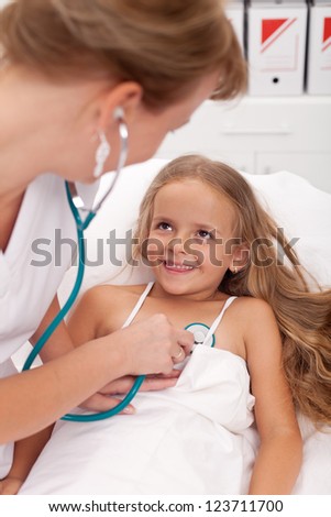 Health-care professional checking up on little girl - happy recovery concept