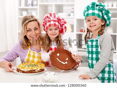 Little chef girls with their mother making a cake in the kitchen