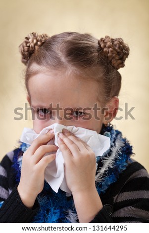 Little girl with the flu having red eyes - blowing nose