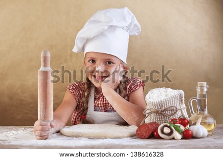 Little girl making pizza preparing the dough and other ingredients Little girl making pizza preparing the dough and other ingredients