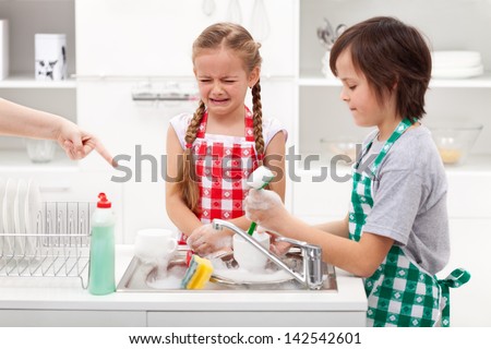 Do the dishes - upset kids ordered to help in the kitchen by washing tableware